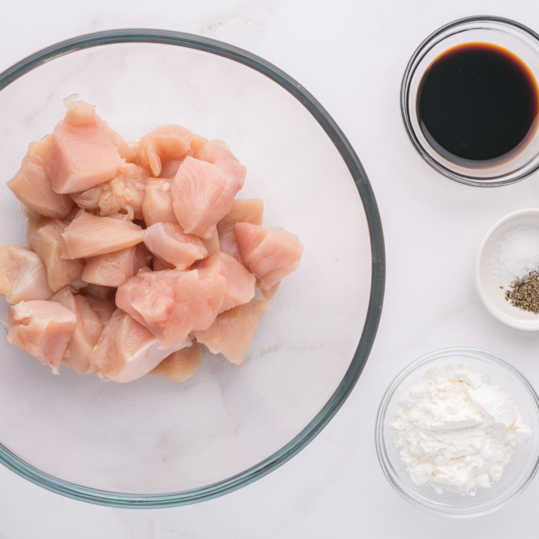 Cut the chicken into bite size pieces, and place into a large glass bowl.