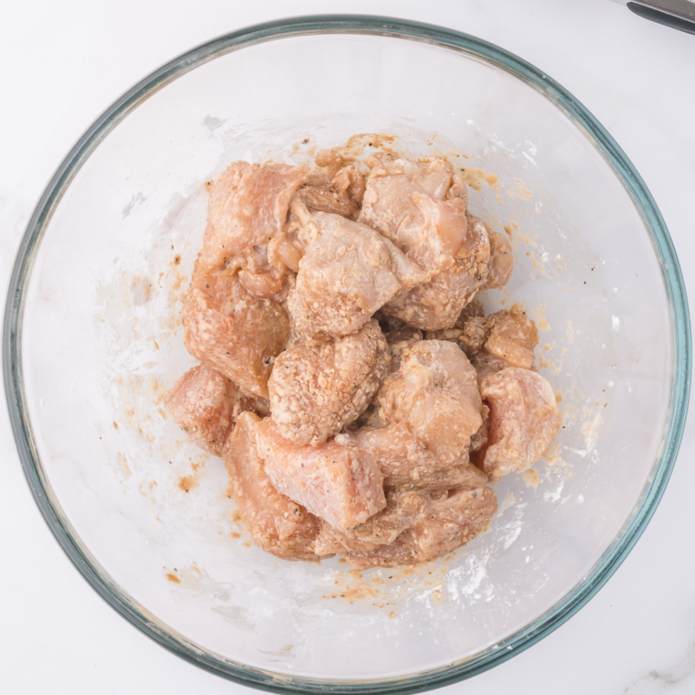 Toss the chicken bites with flour, Kosher salt and black pepper, tossing with tongs, to fully cover the chicken pieces.