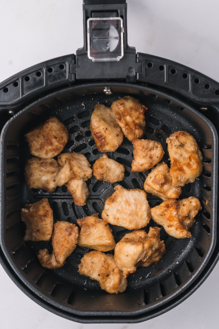 Cooked Chicken Nuggets In air fryer basket.