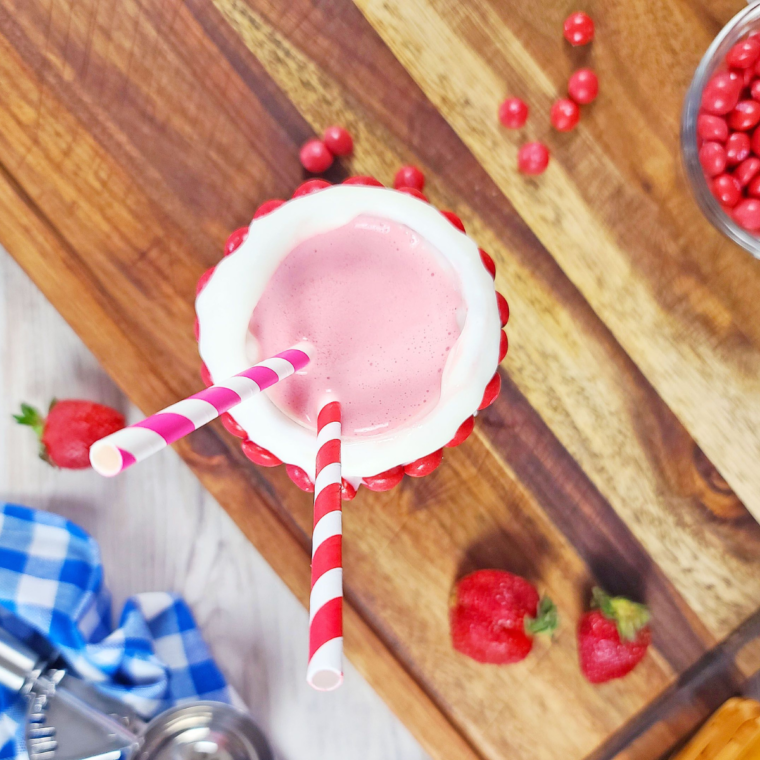 Copycat Wendy's Strawberry Frosty in a tall glass topped with whipped cream."