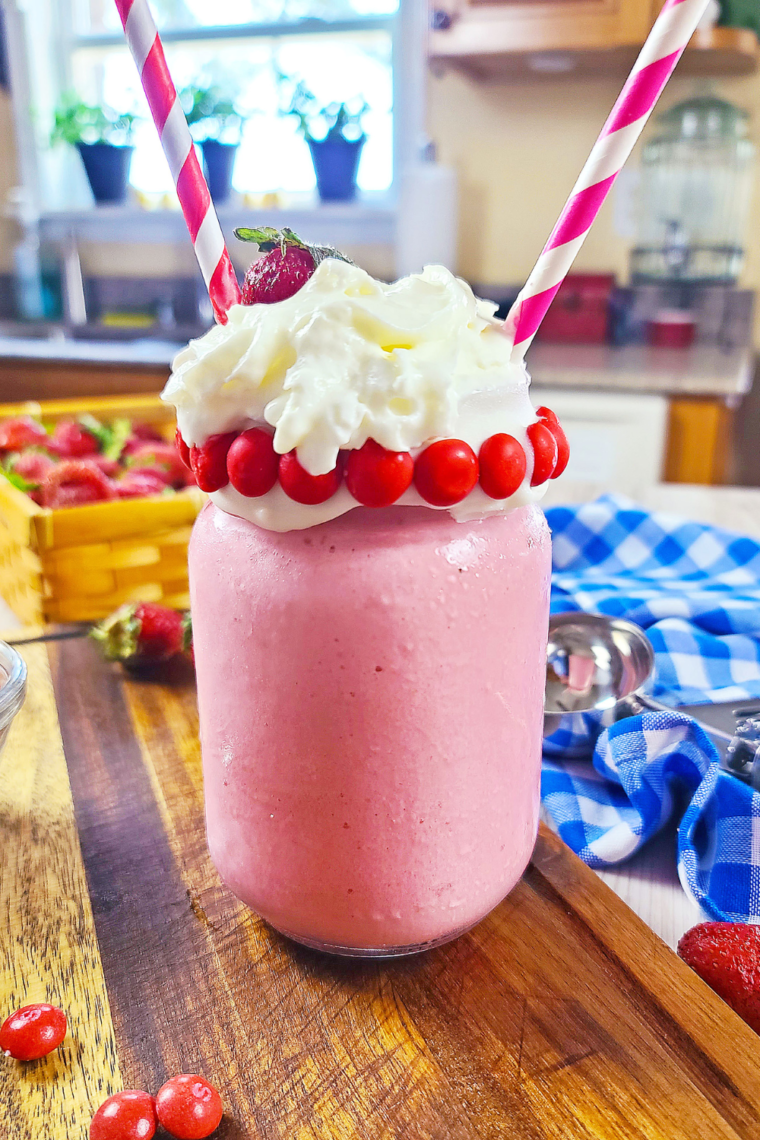 Homemade Strawberry Frosty served with a straw, capturing the creamy texture.