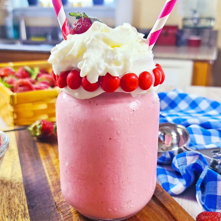 Creamy Copycat Wendy's Strawberry Frosty in a cup with a straw.