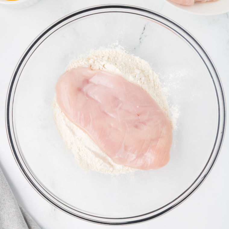 Dip the chicken into the flour.