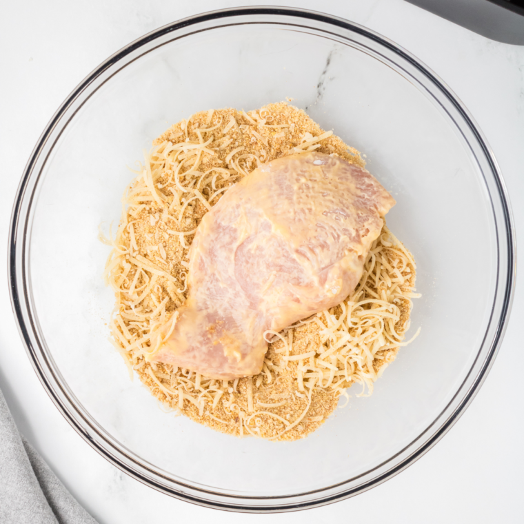 Coating the chicken with the breadcrumbs and seasonings.