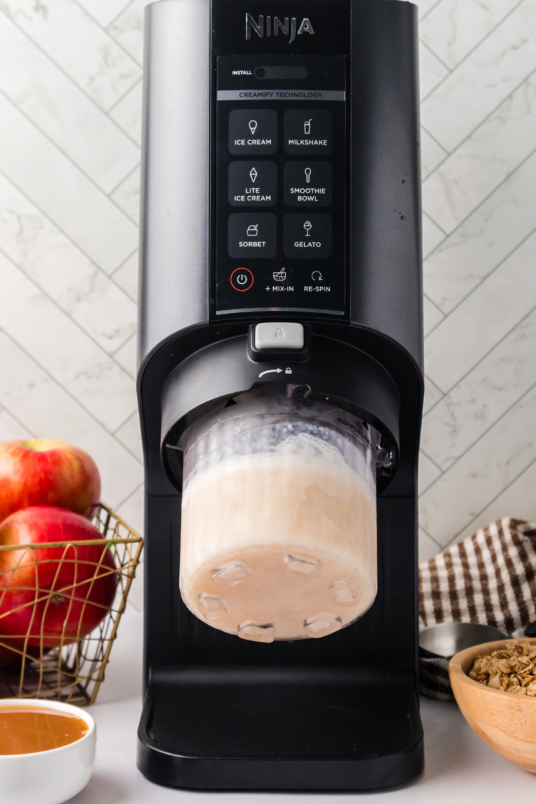 Ninja Creami machine processing the frozen apple cobbler mixture, turning it into creamy ice cream.