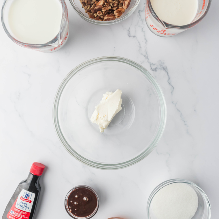 Ingredients for Ninja Creami Turtle Pecan Cluster Blizzard including milk, cream, sugar, vanilla, pecans, caramel sauce, and chocolate syrup