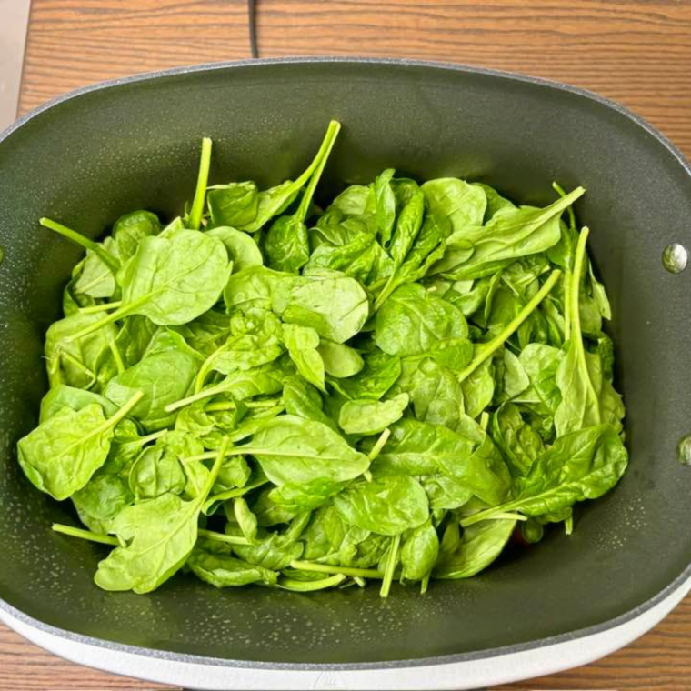 Add the fresh spinach on top of the pasta and sauce.