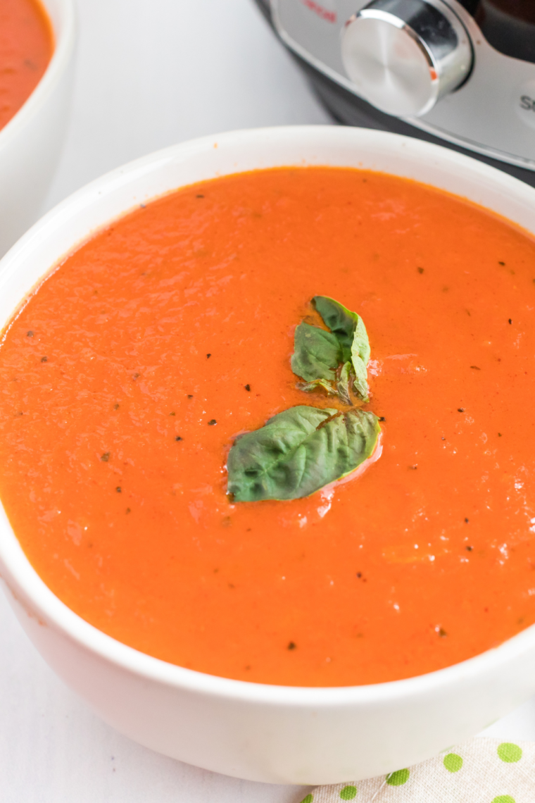 Serving of Olive Garden-inspired tomato basil soup in a rustic bowl.