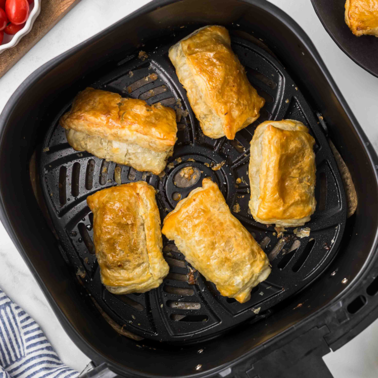 Cooked dolmas in air fryer basket.