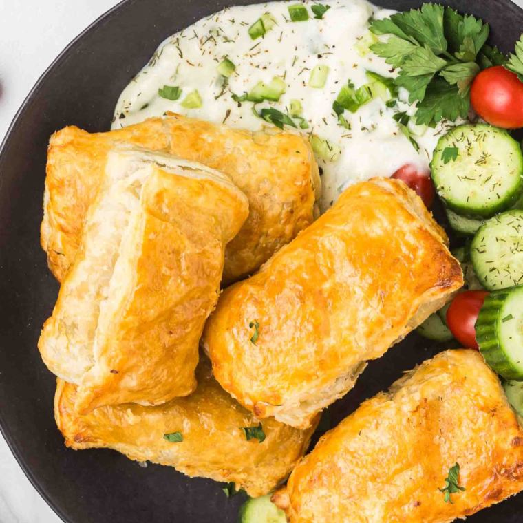 Deliciously arranged Air Fryer Stuffed Grape Leaves (Dolmas) served on a plate, showcasing their golden-brown exterior and vibrant green leaves.