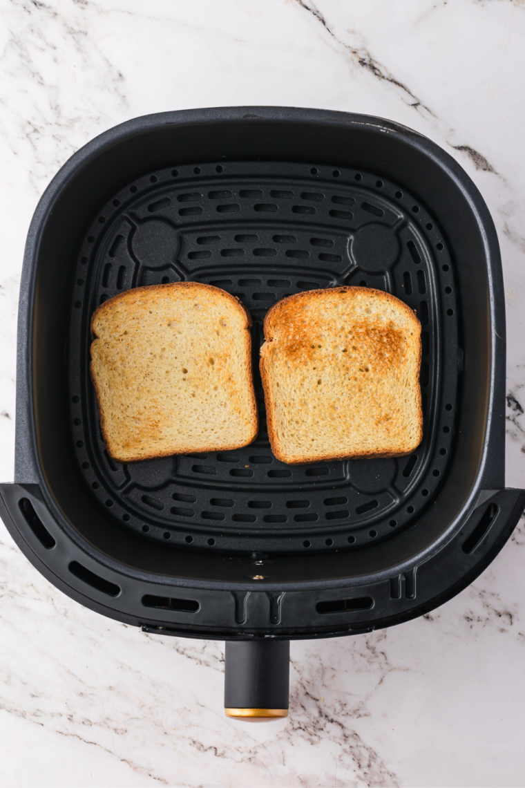 Perfectly toasted bread in the air fryer basket. Ready to add toppings.