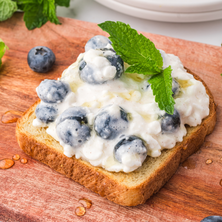 Golden-brown air fryer blueberry cottage cheese toast topped with fresh blueberries and a drizzle of honey.