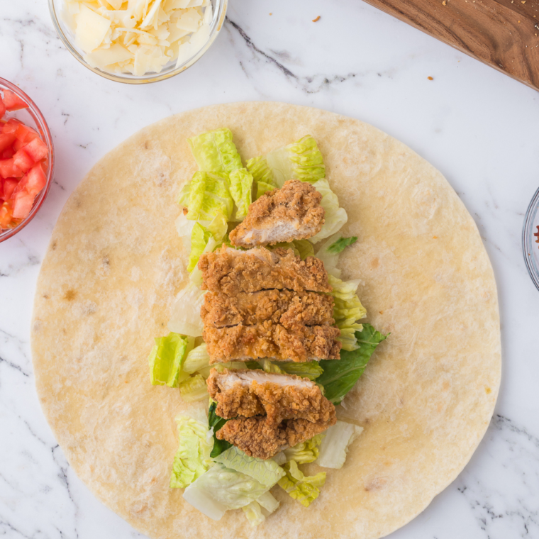 Assembling the Air Fryer Caesar Wraps on kitchen counter.