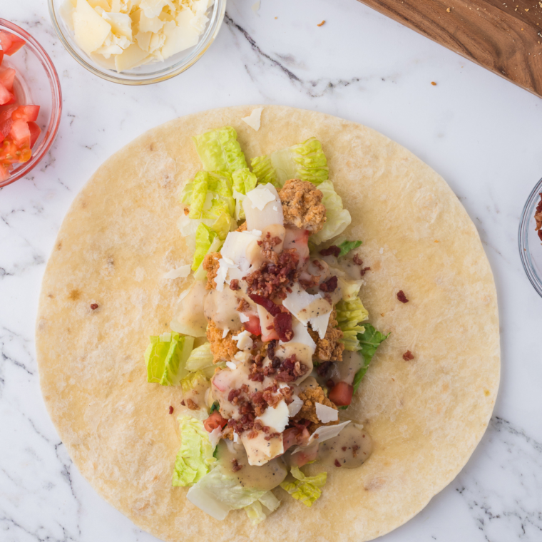 "Flour tortilla filled with crispy chicken, Caesar dressing, and romaine lettuce."