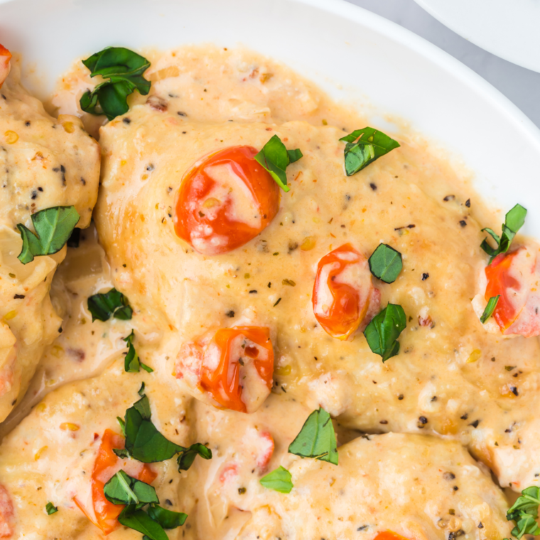 Juicy Air Fryer Marry Me Chicken topped with a creamy sauce and fresh herbs on a white plate.