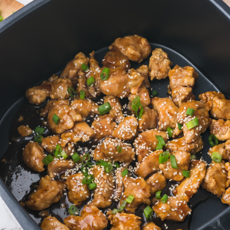 Close-up of air-fried spicy chicken coated in a glossy sauce.