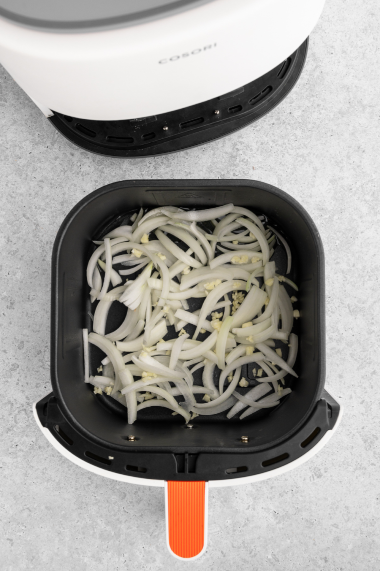 Cooking the onions and garlic in the air fryer basket.