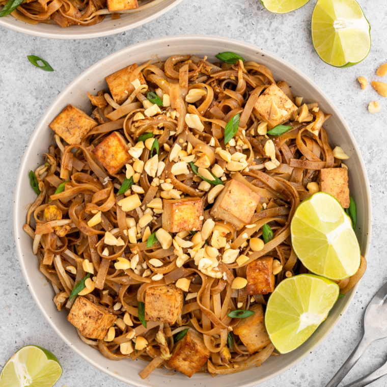 "Serving plates of Air Fryer Pad Thai with noodles, green onions, and crushed peanuts."