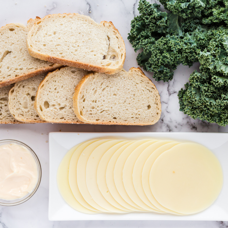 Ingredients needed for Air Fryer Provolone Broccoli Rabe Sandwich on kitchen table.