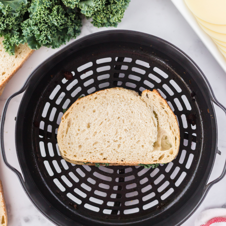 Placing the Air Fryer Provolone Broccoli Rabe Sandwich in the air fryer basket.