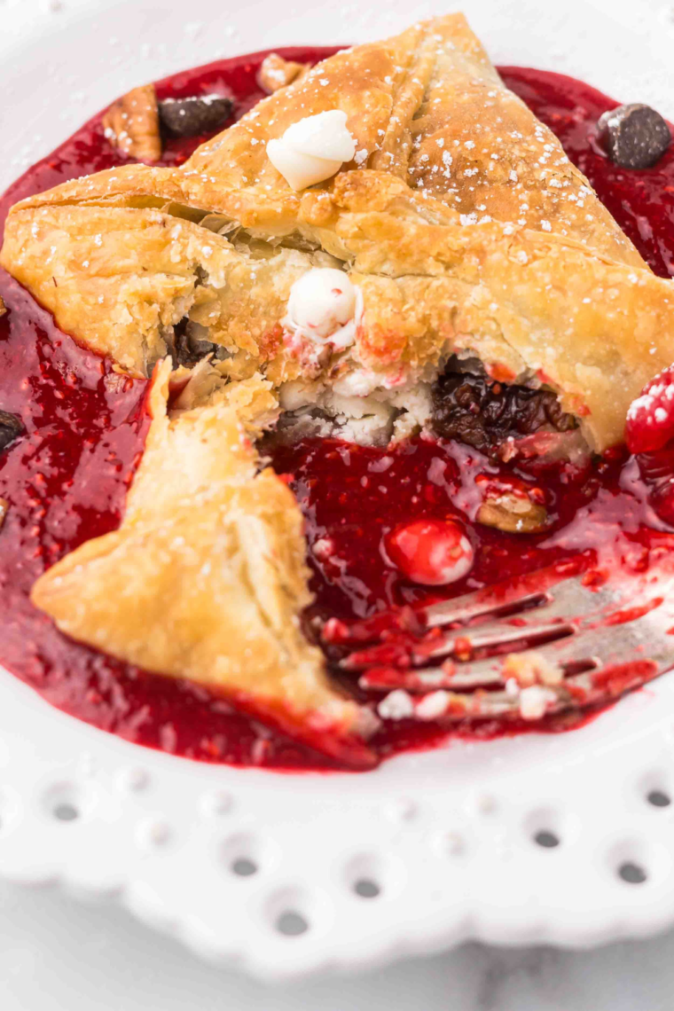 Flaky Air Fryer Raspberry Chocolate Puffs with golden pastry, rich chocolate filling, and raspberry sauce, served on a plate."