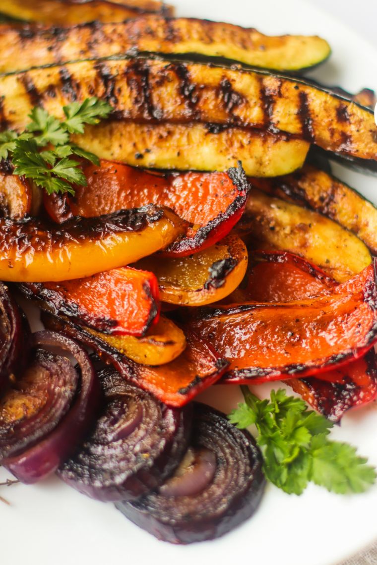 Mixed vegetables cooking on a Blackstone griddle with a balsamic glaze.