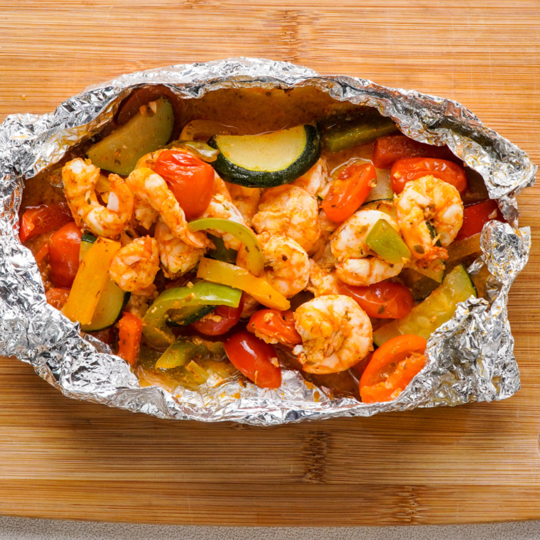 Air Fryer Shrimp Foil Packets garnished with fresh parsley on a rustic plate