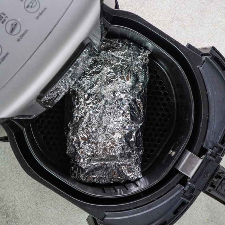 Place shrimp foil packets in the air fryer basket.