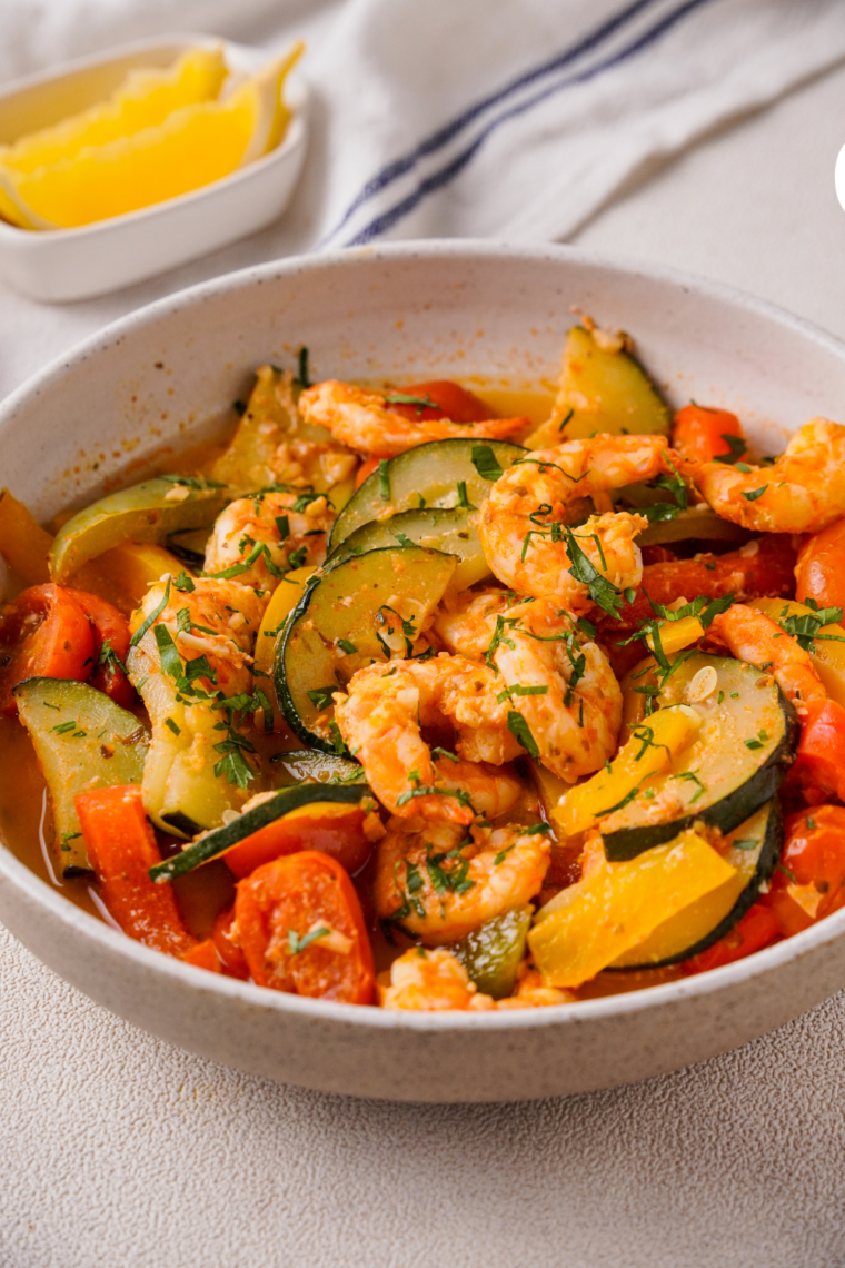 "Golden, tender shrimp and colorful vegetables cooked in foil packets in the air fryer, garnished with fresh parsley and lemon wedges for a vibrant, healthy meal."