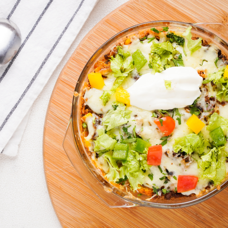 Close-up of cheesy Air Fryer Taco Fiesta Bubble Up Casserole topped with diced tomatoes and green onions.
