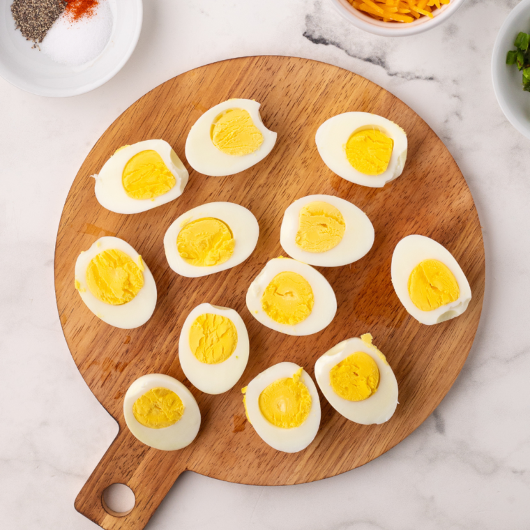 "Peel the cooled eggs and slice them in half lengthwise."