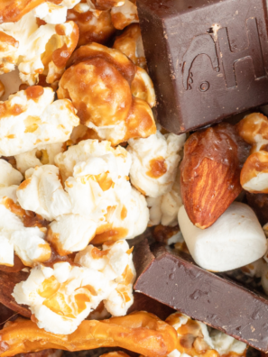 A bowl of homemade Moose Munch Caramel Popcorn, featuring caramel-coated popcorn, nuts, and drizzled chocolate, served as a festive snack.