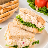 : A serving of Copycat Chicken Salad Chick Classic Carol on a bed of greens with crackers on the side.