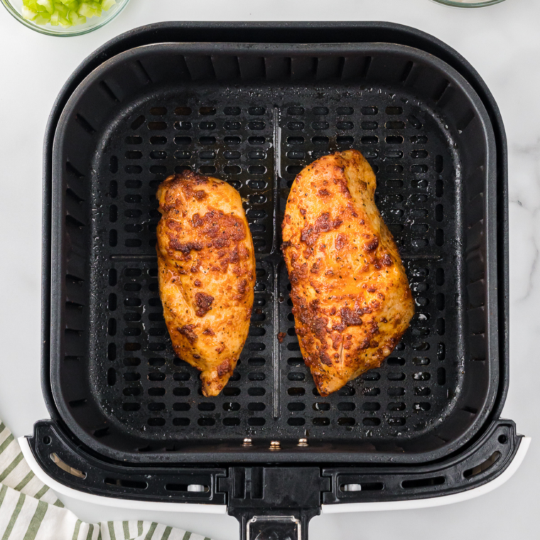 Cooked chicken in the air fryer basket.