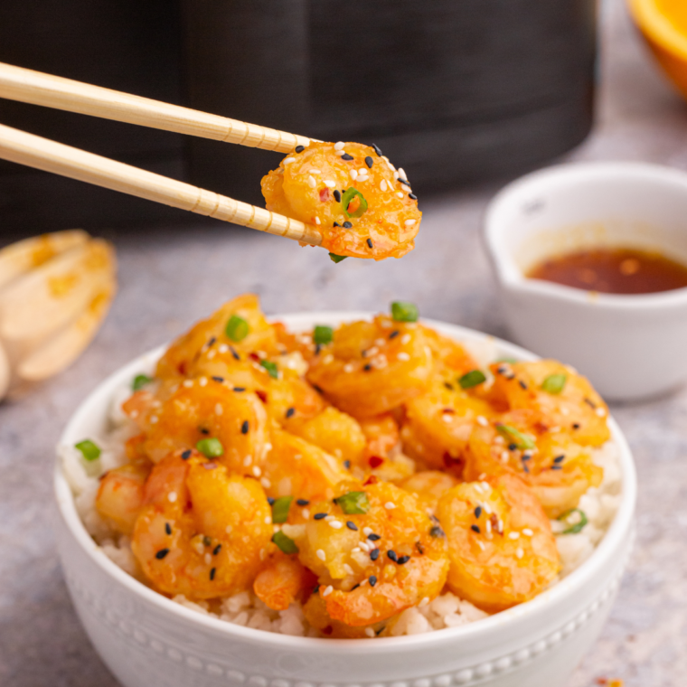 "Copycat P.F. Chang’s Dynamite Shrimp served crispy with a creamy, spicy sauce, garnished with green onions."