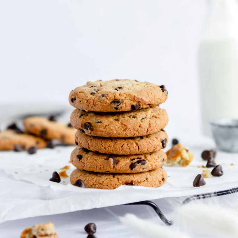 Close-up of freshly baked Copycat Potbelly Oatmeal Chocolate Chip Cookies, golden brown with melty chocolate chips on a rustic cooling rack.