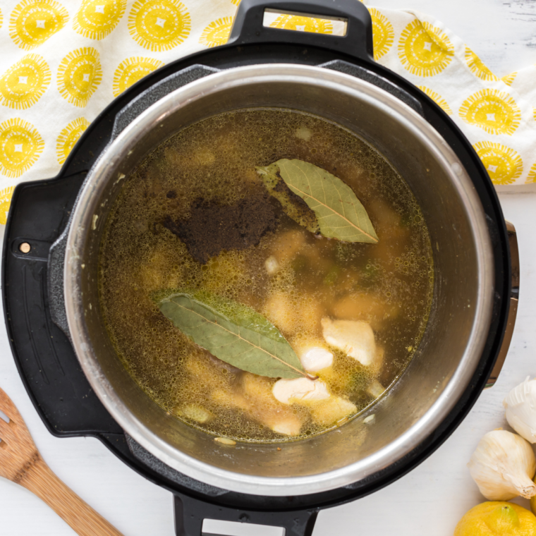 Pouring chicken broth and water into the pot for Demo’s Chicken and Rice Soup.