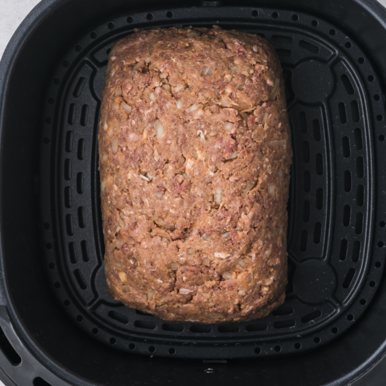 "Air fryer basket with Golden Corral-inspired meatloaf topped with ketchup glaze"