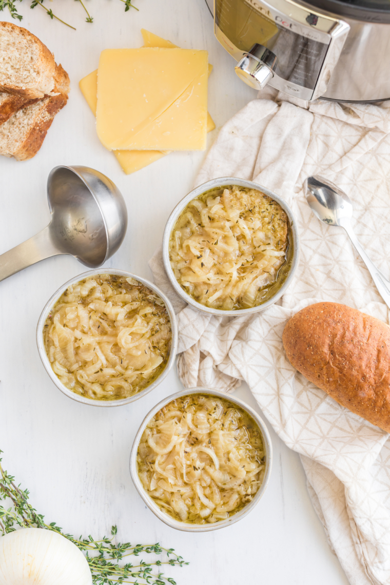 Bowl of Longhorn French Onion Soup topped with melted cheese and toasted baguette slices, served in a rustic bowl."