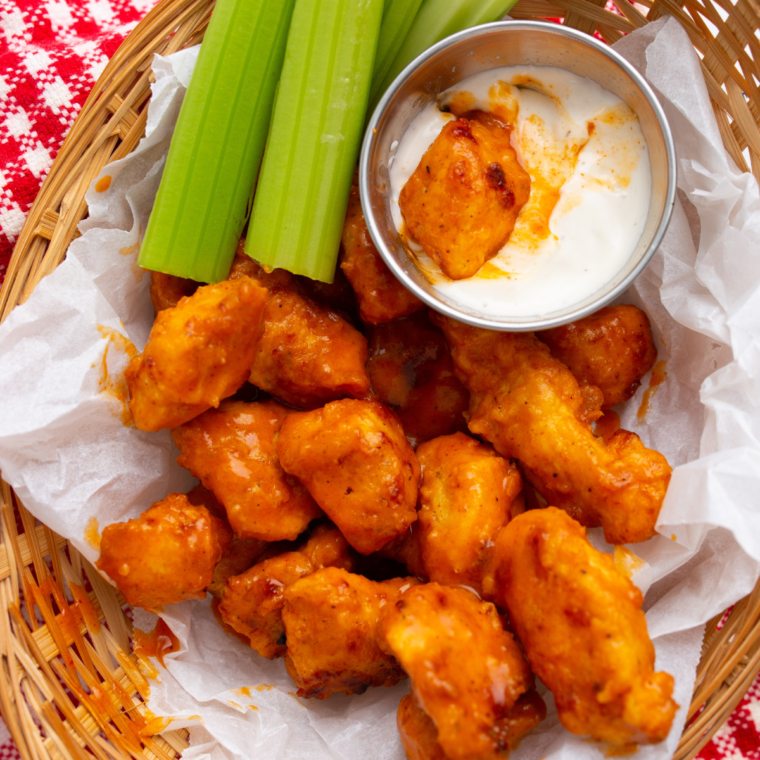 Plate of crispy Longhorn Spicy Chicken Bites with a spicy dipping sauce on the side"