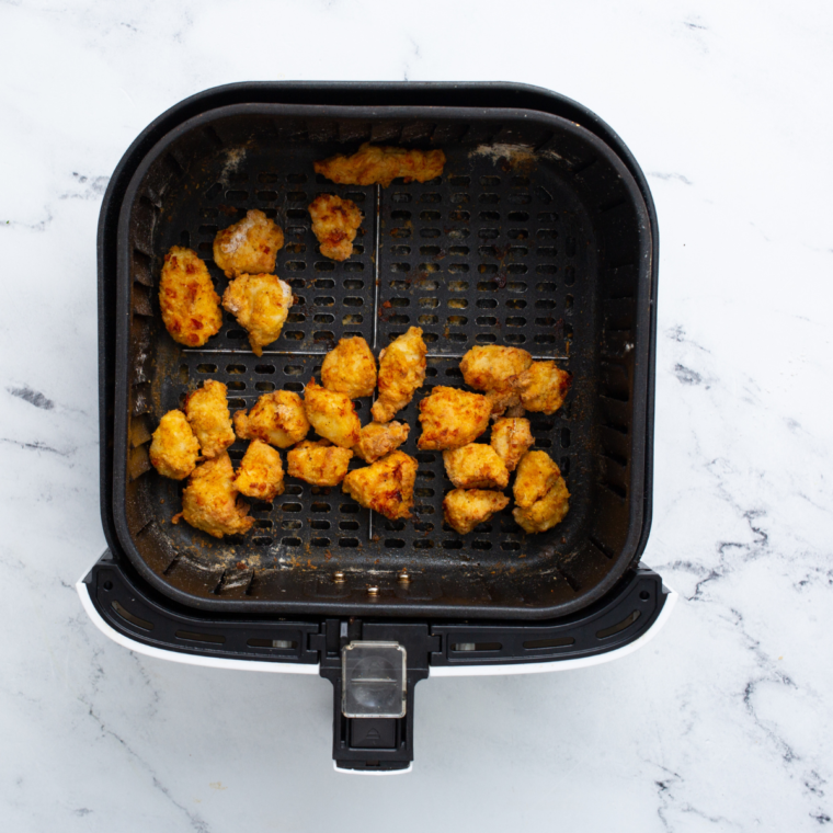 Crispy, spicy chicken bites in the air fryer basket"