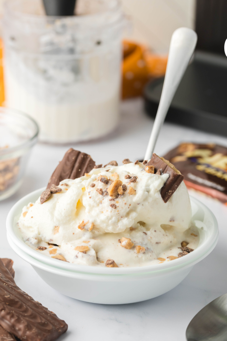 Garnishing the Heath Blizzard with extra toffee bits and whipped cream.