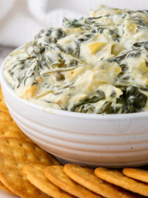"Delicious and creamy Ninja Foodi Possible Cooker Pro Spinach Artichoke Dip with melted cheese and fresh vegetables."