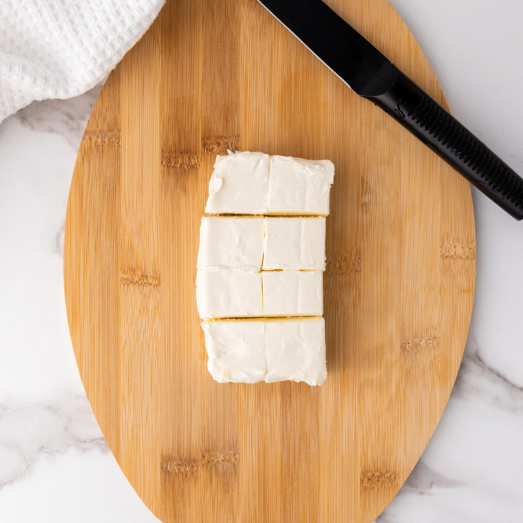 cutting cream cheese into smaller pieces.
