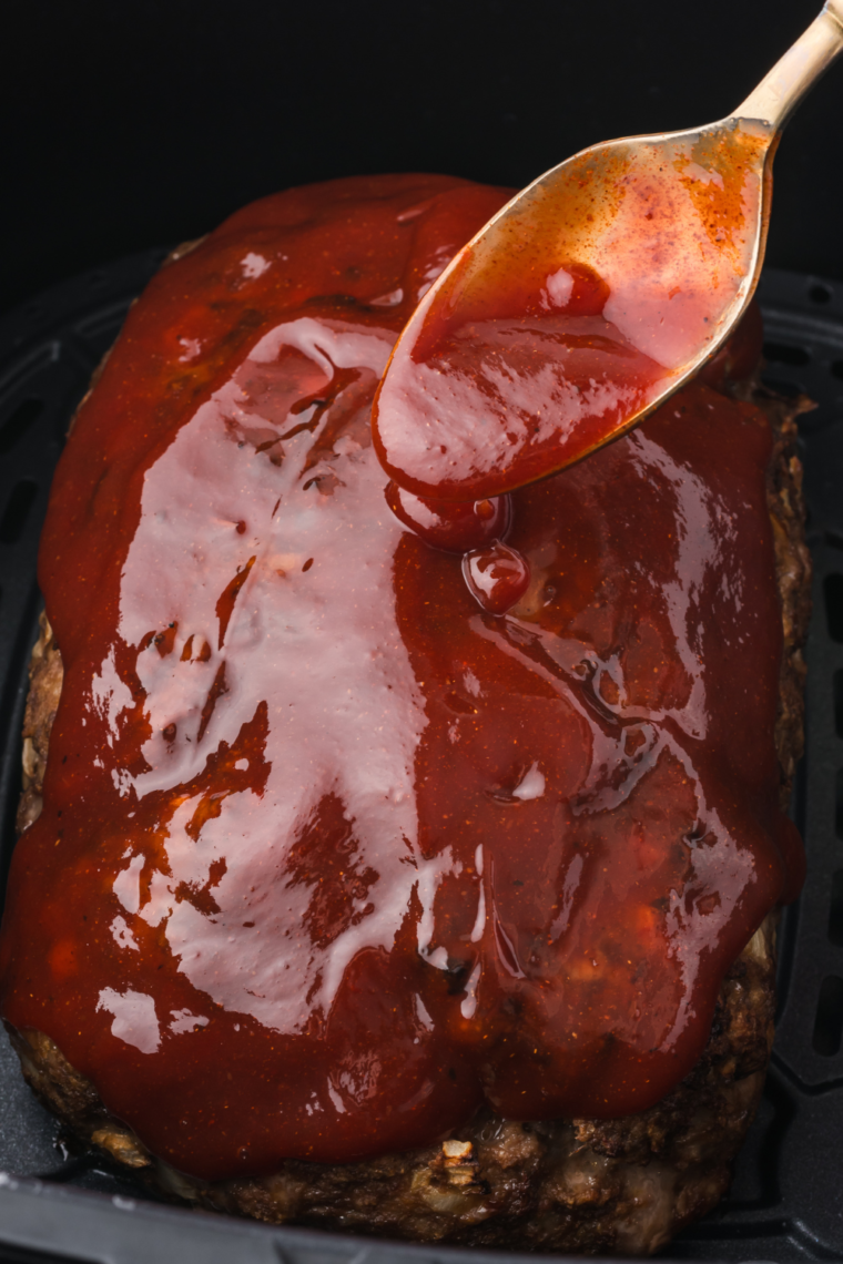 "Spreading spicy jam glaze on meatloaf before air frying."