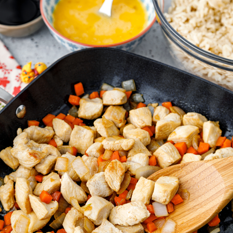 A vibrant plate of Subgum Fried Rice with mixed vegetables, scrambled eggs, and chunks of chicken, all stir-fried to perfection.