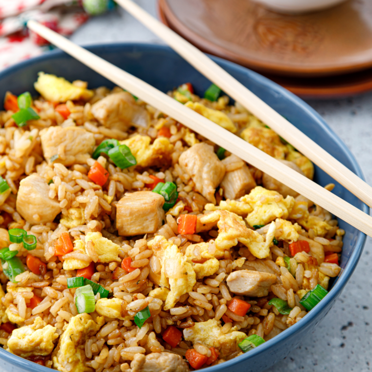 A vibrant plate of Subgum Fried Rice with mixed vegetables, scrambled eggs, and chunks of chicken, all stir-fried to perfection.