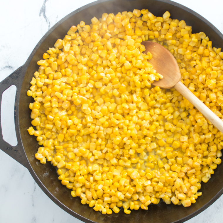 Adding frozen corn to the melted butter in the saucepan for Texas Roadhouse Buttered Corn.