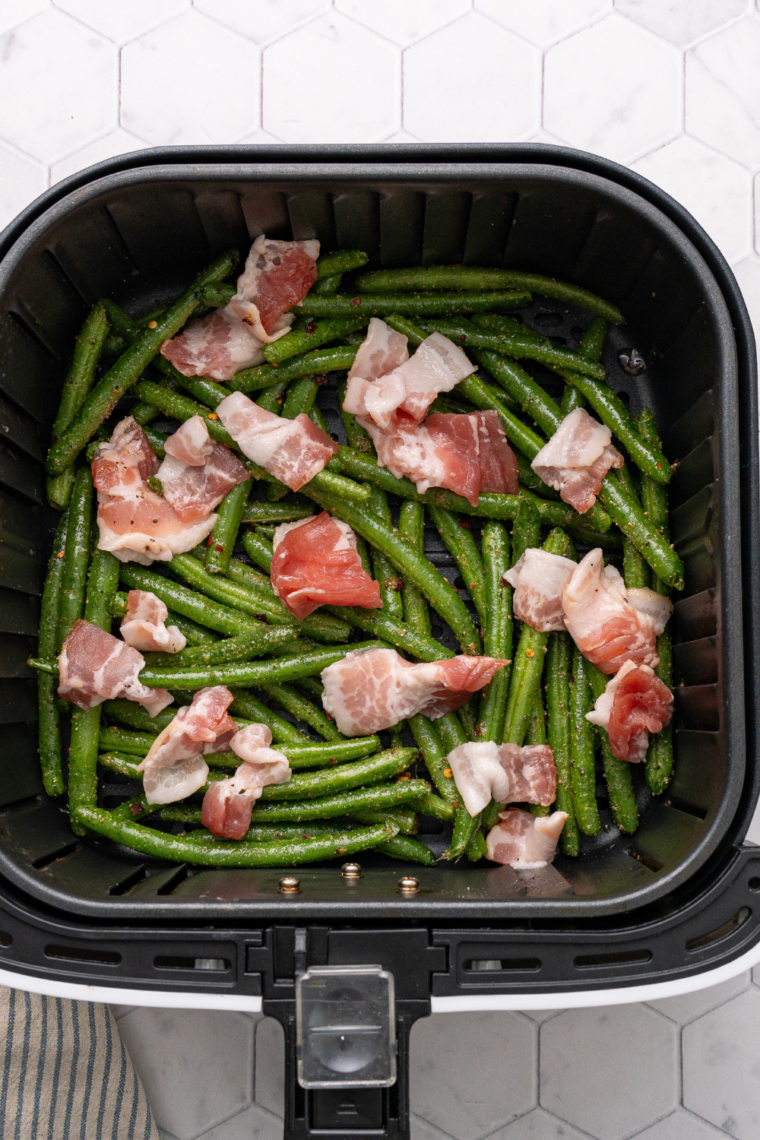 Adding Texas Roadhouse Copycat Recipe ingredients to the air fryer basket.