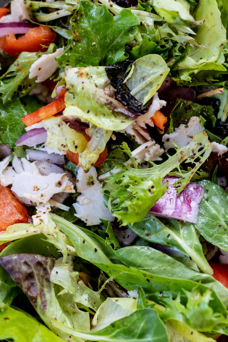 Texas Roadhouse Sweet Italian Dressing served on a fresh salad, showcasing its creamy texture and vibrant color.